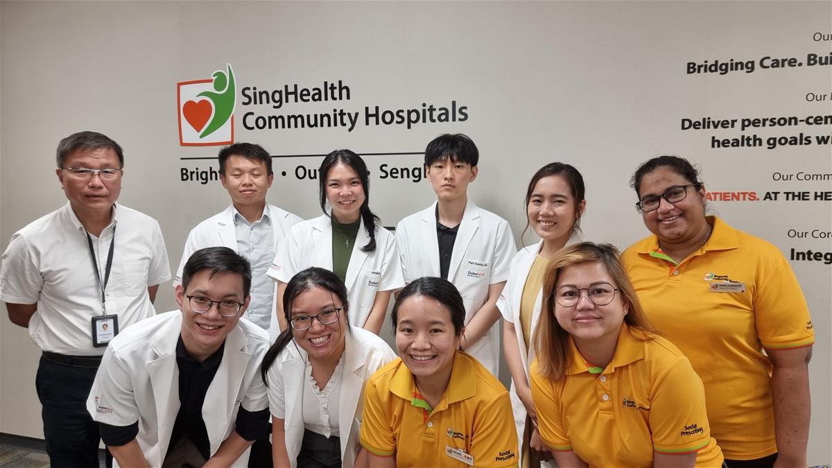 : Prof Lee (far left), Chen and her classmates (middle; in white coats) and Ms Sing and her colleagues (far right; in orange shirts) at OCH on the day of the attachment