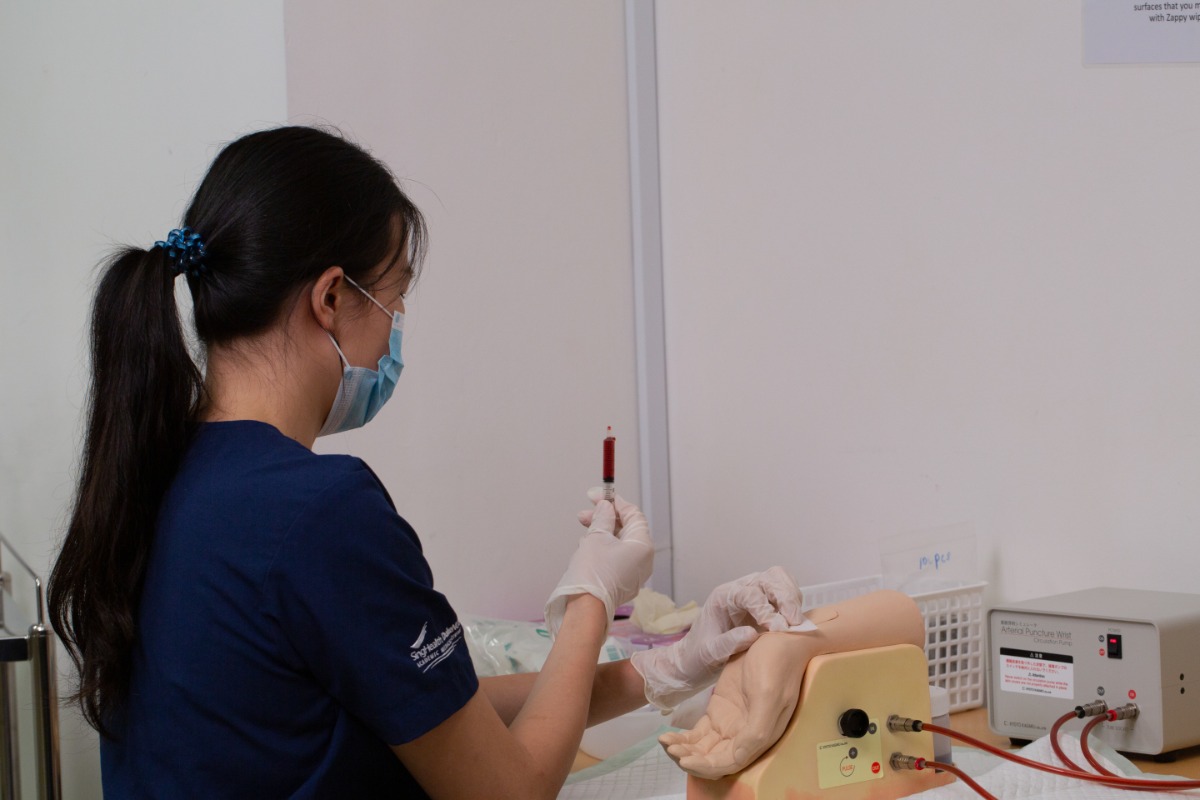 CPC-223 Fountain of knowledge: A student learns to draw blood from a task trainer that models an arm. // Credit: Duke-NUS Medical School