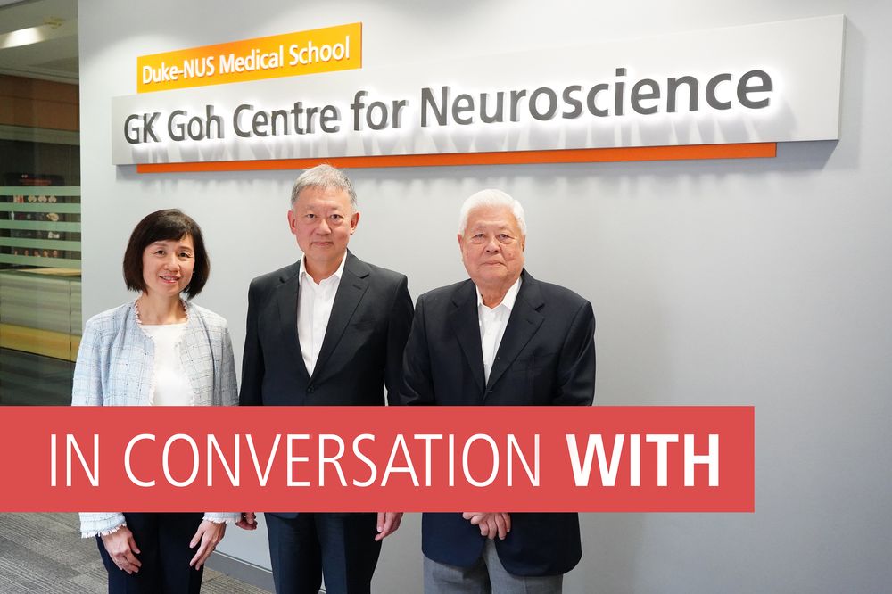 Three people standing in front of a sign reading GK Goh Centre for Neurosience, which they funded