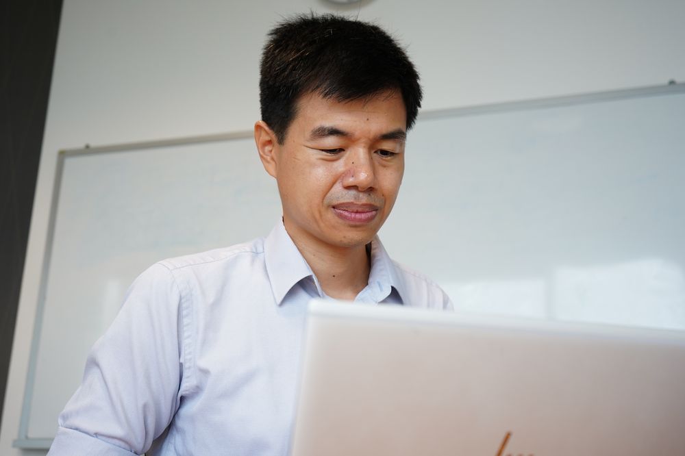 A portrait of Ignasius Jappar, a cardiologist who is looking at his laptop