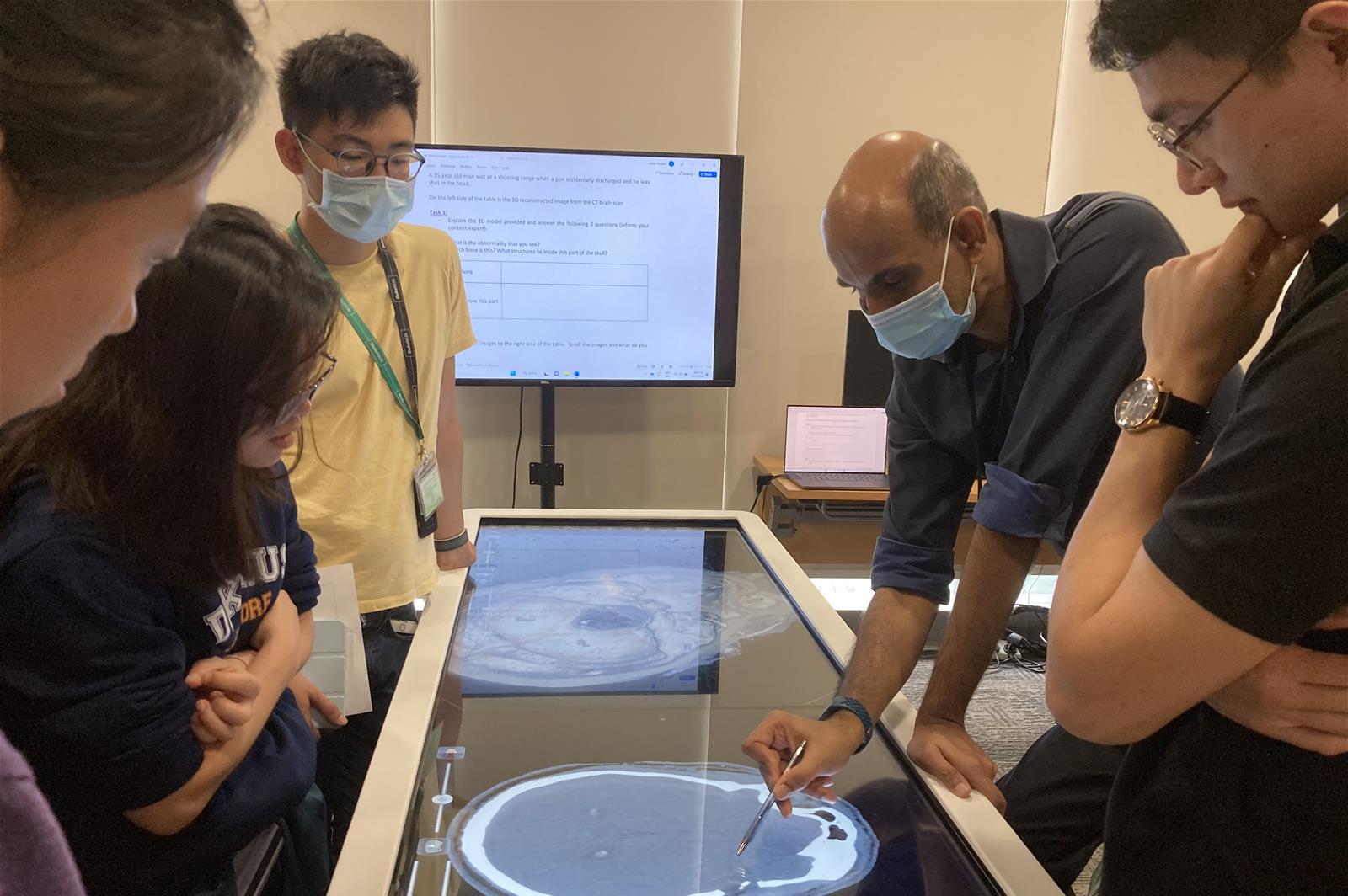 Clinical Assistant Professor Jai Prashanth Rao points out structures on a brain CT scan during a tutorial session