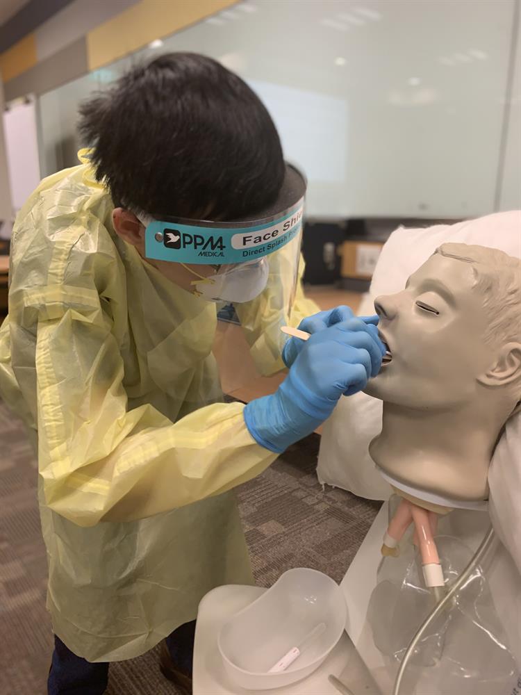 Students practise their examination skills on a manikin and simulated patients