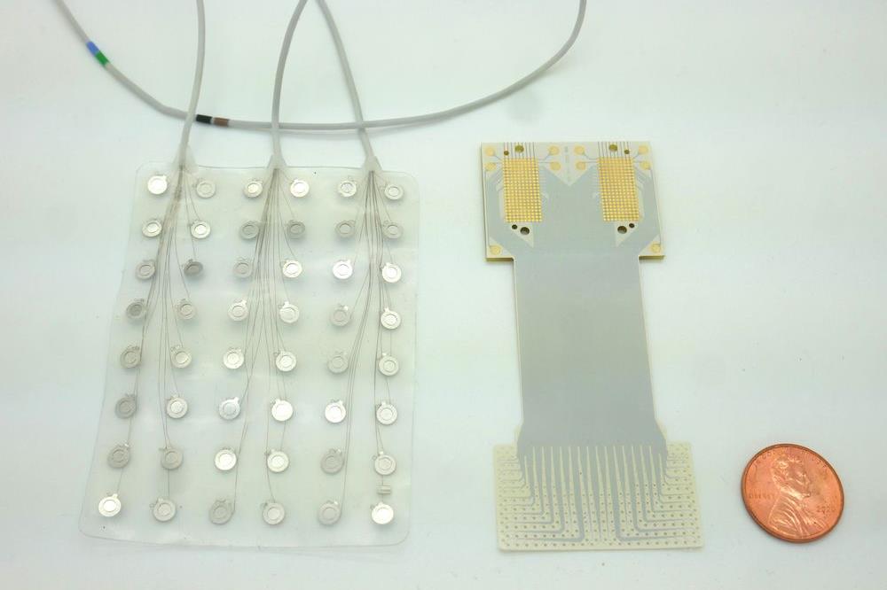 A close-up of the new brain implant developed by Duke scientists on the right, next to a coin for scale. To the left is a current speech prosthetic with 128 electrodes