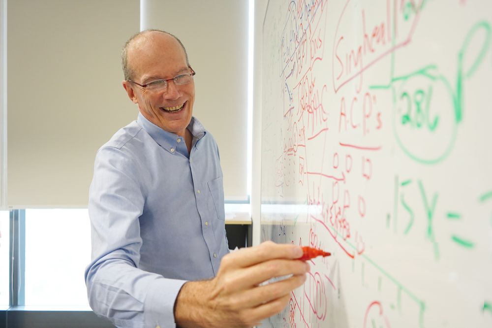 Roger Vaughan writes on his whiteboard