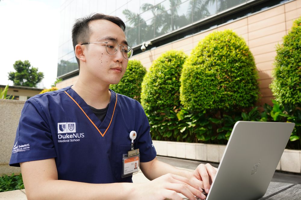 A male Duke-NUS medical student looks at his laptop
