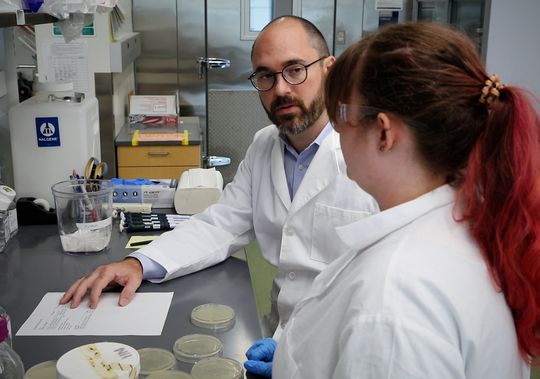 A male and female research in the lab talking about their influenza vaccine discovery