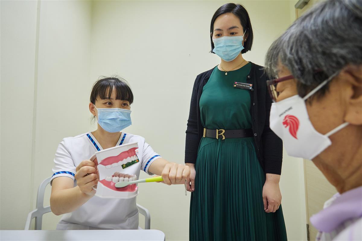 A community nurse educating an elderly patient on the importance of oral hygiene// Credit: Singapore Health