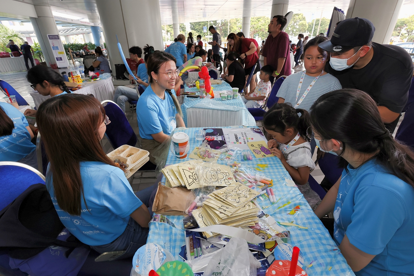 Student volunteers interact with carnival attendees at a booth // Credit: Duke-NUS
