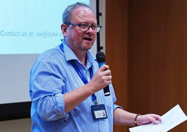A Caucasian man speaking into a microphone