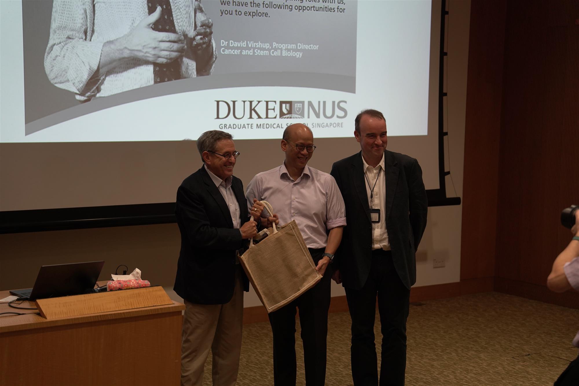 Prof David Vishup (left) receives a token of appreciation from Prof Ong Sin Tiong (centre), and Assoc Prof Nicholas Tolwinski (right)