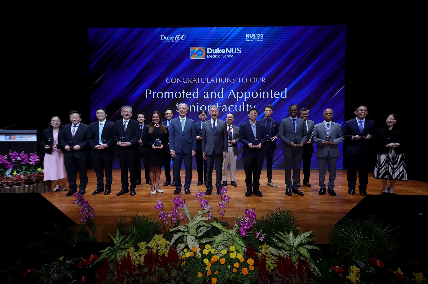 The promoted and appointed senior faculty with Dean Coffman and Mr Goh onstage