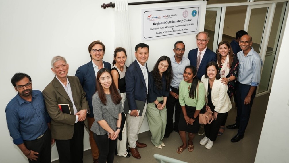 A group of people crowding together for a commemorative photo at the Jaffna Regional Collaborating Centre of the SingHealth Duke-NUS Global Health Institute's regional network