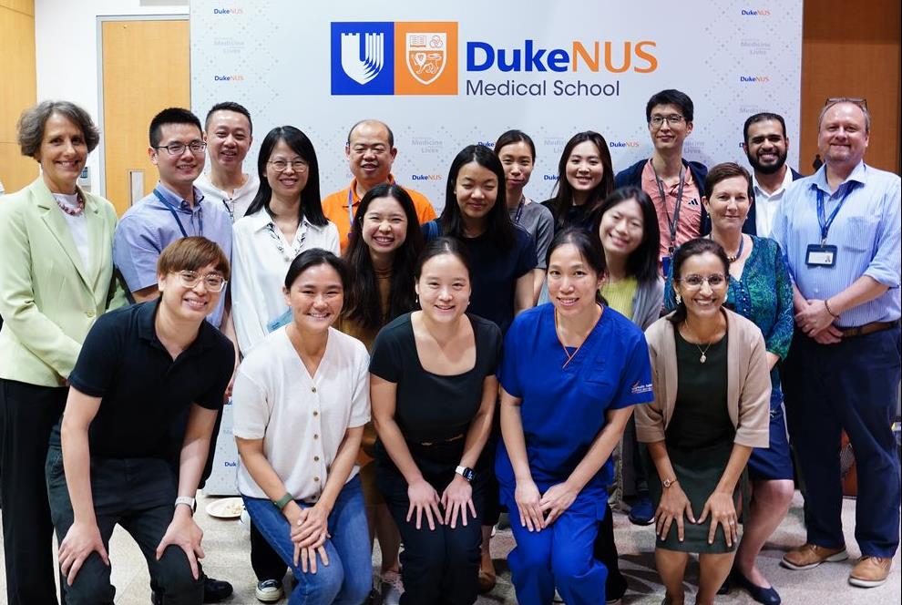 Course participants and course organisers pose for a group photo in front of a Duke-NUS backdrop