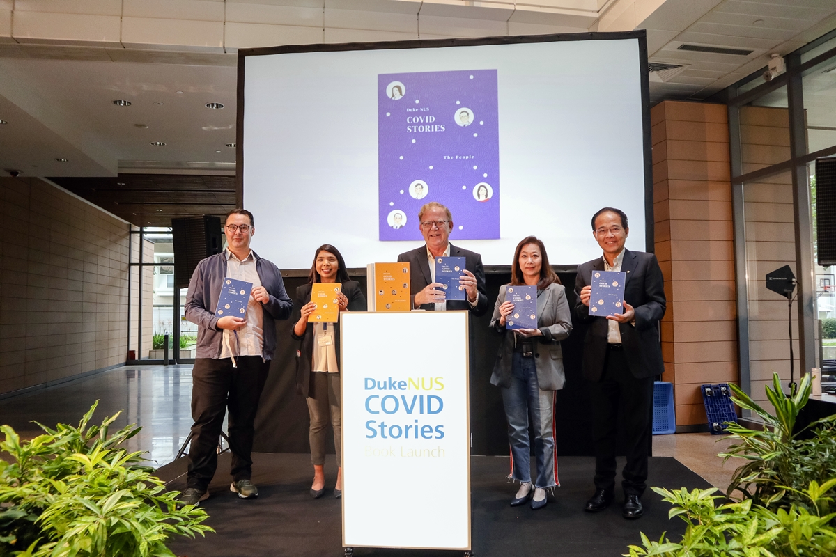Five people standing on stage after launching the Duke-NUS COVID Stories book