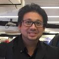 Photo of Jonathan Selvasegaram with black glasses in a black shirt